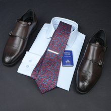 a tie, dress shirt, and dress shoes are laid out