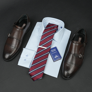 a dress shirt, tie, dress shoes and a business card