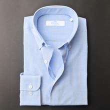 a blue and white checkered shirt on a black surface