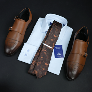 a tie, dress shoes, and a shirt on a black surface