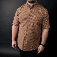 a man in a brown and black checkered shirt