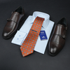 a dress shirt, tie, and dress shoes on a black surface