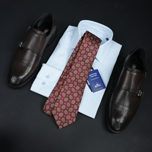 a tie, dress shirt, and dress shoes on a table