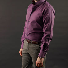a man in a purple shirt is posing for a picture