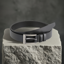 a black belt sitting on top of a rock