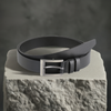 a black belt sitting on top of a rock