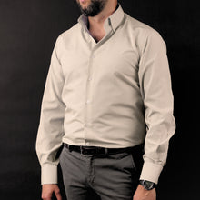 a man in a dress shirt and tie posing for a picture