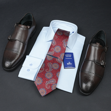 a tie, dress shoes, and a shirt are laid out