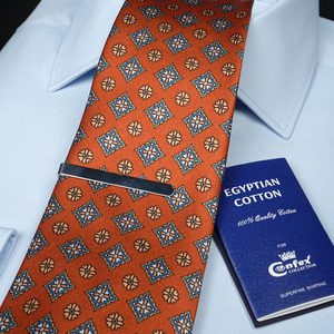 an orange tie with a blue book next to it