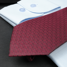 a close up of a red tie on a white shirt