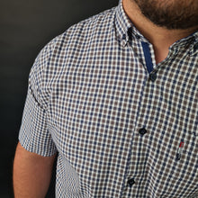 a man with a beard wearing a blue and white checkered shirt