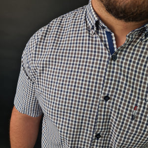 a man with a beard wearing a blue and white checkered shirt