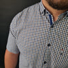a man with a beard wearing a blue and white checkered shirt
