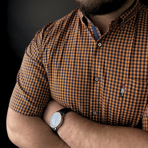 a man with his arms crossed wearing a watch