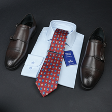 a dress shirt, tie, and dress shoes on a table