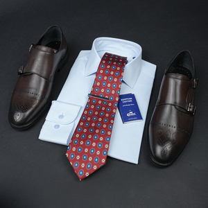 a dress shirt, tie, and dress shoes on a table