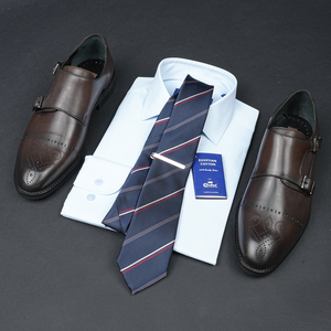 a dress shirt, tie, and dress shoes on a table