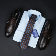 a dress shirt, tie, and dress shoes on a black surface