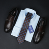 a dress shirt, tie, and dress shoes on a black surface