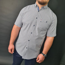 a man standing in front of a black wall