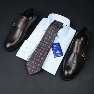 a tie, dress shoes, and a business card on a table