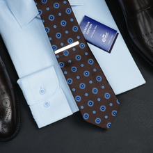 a close up of a tie and dress shoes
