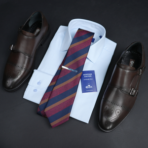 a dress shirt, tie, and dress shoes are laid out
