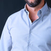 a man with a beard wearing a blue shirt