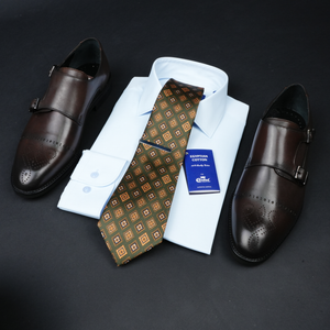 a tie, dress shoes, and a business card on a black surface