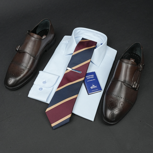 a dress shirt, tie, and dress shoes are laid out