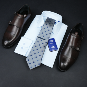 a tie, dress shirt, and dress shoes on a black surface