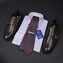 a tie, dress shoes, and a business card on a table