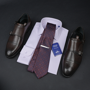 a tie, dress shoes, and a business card on a table