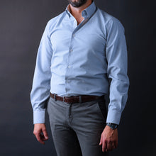 a man in a blue shirt and grey pants