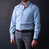 a man in a blue shirt and grey pants
